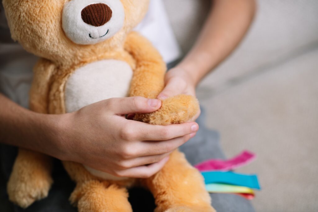 Child squeezing a soft squishy sensory toy with both hands