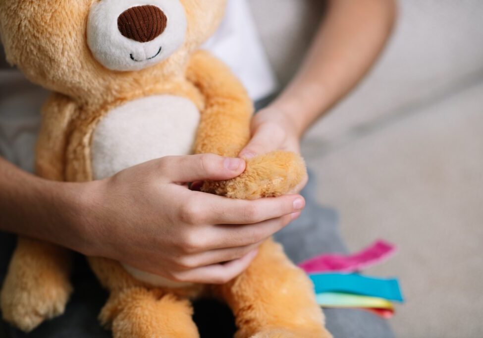 Child squeezing a soft squishy sensory toy with both hands